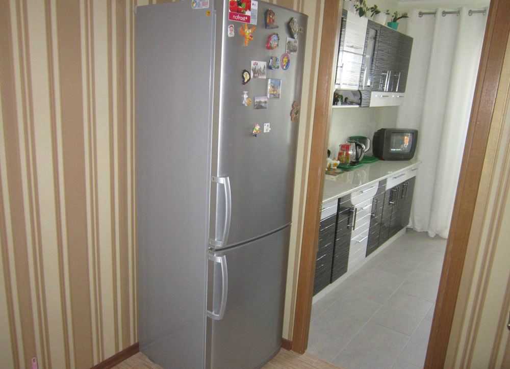 Холодильник стоящий у стены